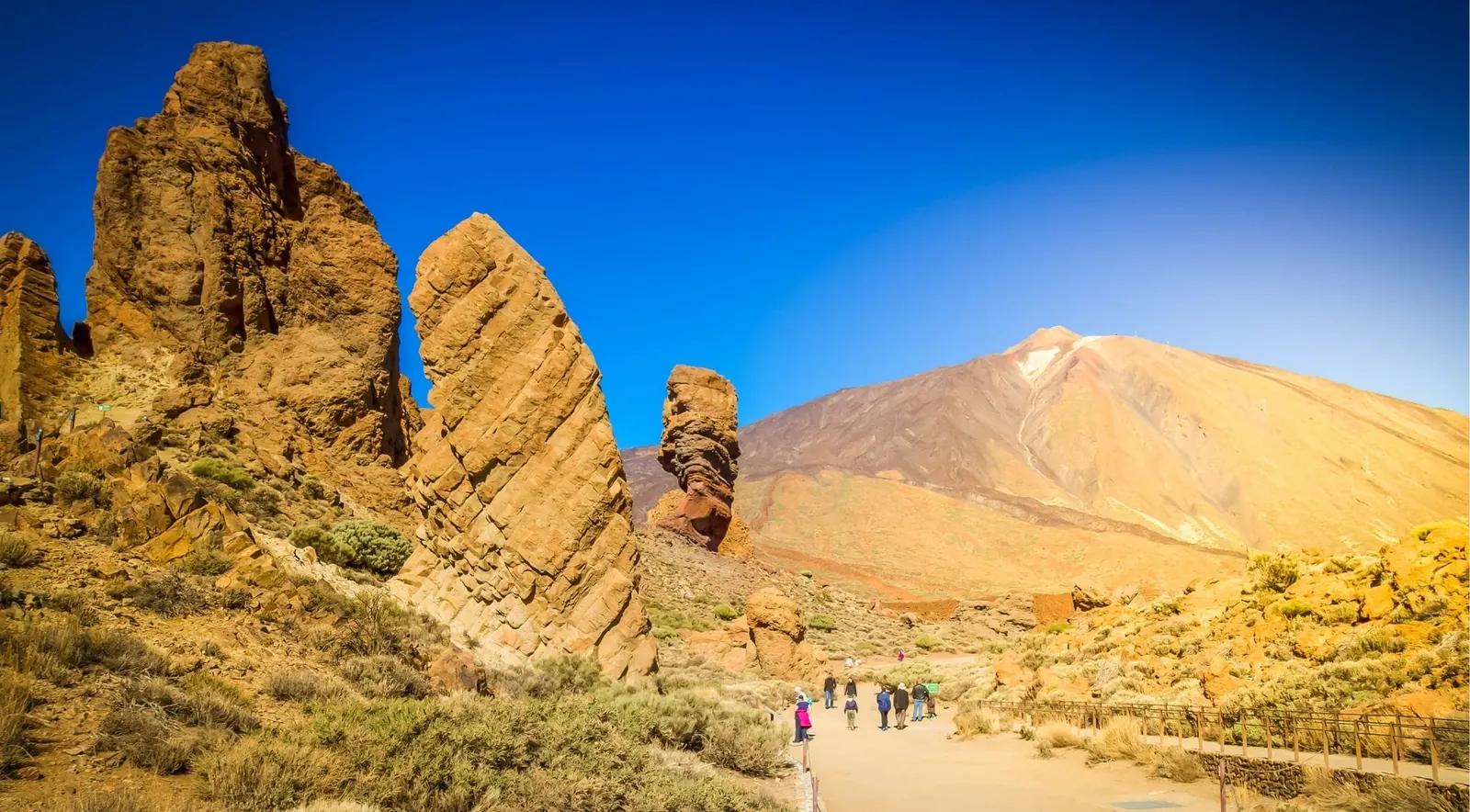 Walkers on the path below the Roques de García with Mount Teide behind