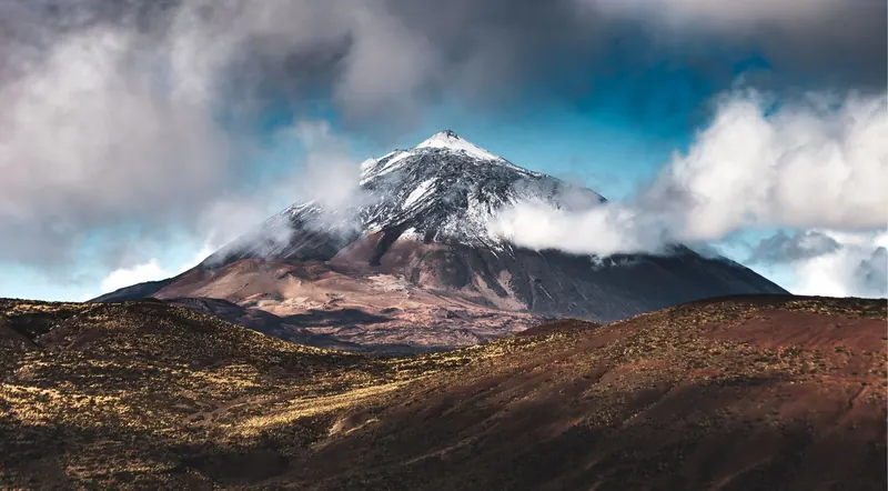 The summit cone of Mount Teide rising through a bank of cloud