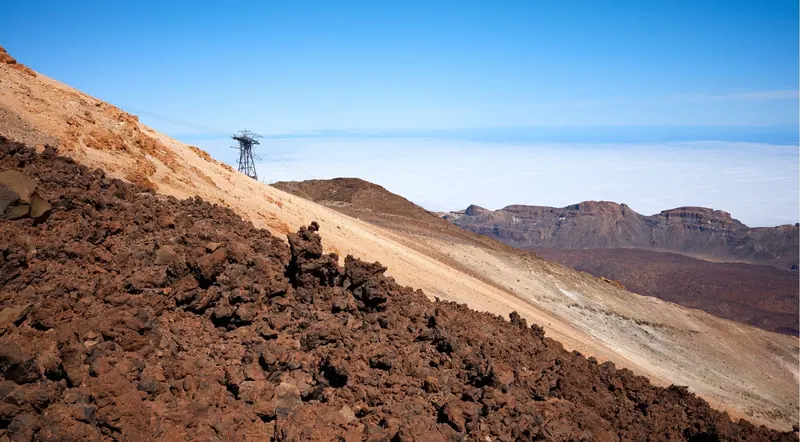 A cable car pylon on Mount Teide's upper slopes above a solid sea of clouds